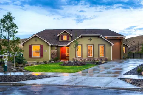 Single-story home with gabled roofs and a neatly trimmed front lawn